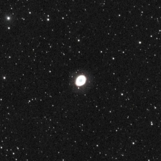The Ring Nebula (M57) photographed from Lakeway, Texas with a ZWO Seestar S50 — a small but unmistakable elliptical ring with a cyan center and pinkish-white rim, set against a dense field of stars in the constellation Lyra.