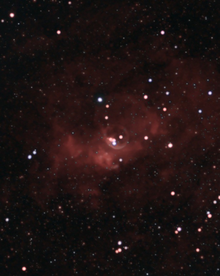 The Bubble Nebula (NGC 7635) photographed from Lakeway, Texas with a ZWO Seestar S50: a thin pale shell around a bright central star, inside a larger cloud of red hydrogen, in a star field of white, blue and orange stars.